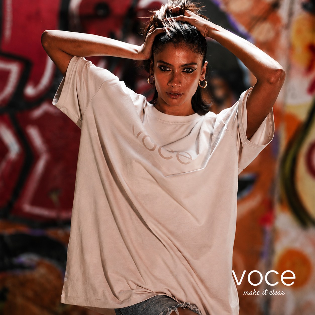 Model in white tee against graffiti