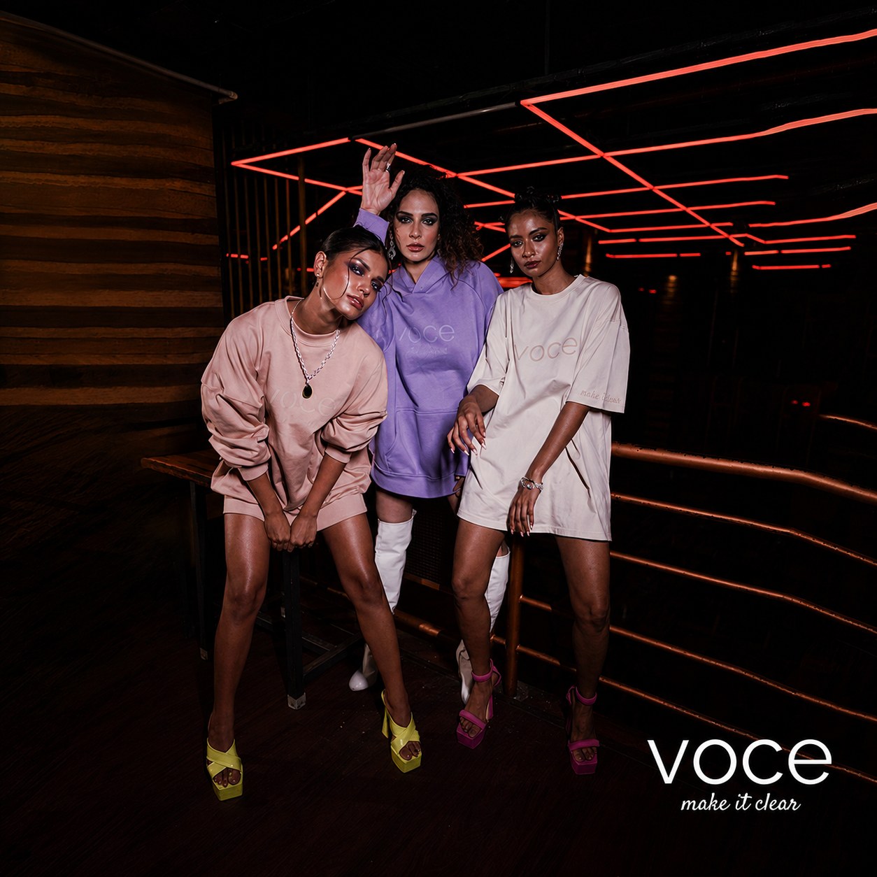 Three models in lilac under neon