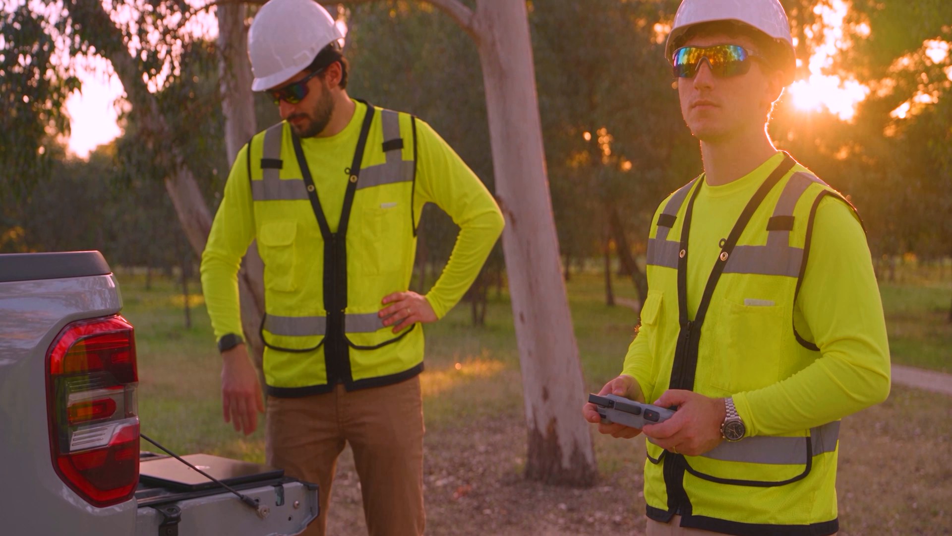 Two crew in hi-vis at sunset
