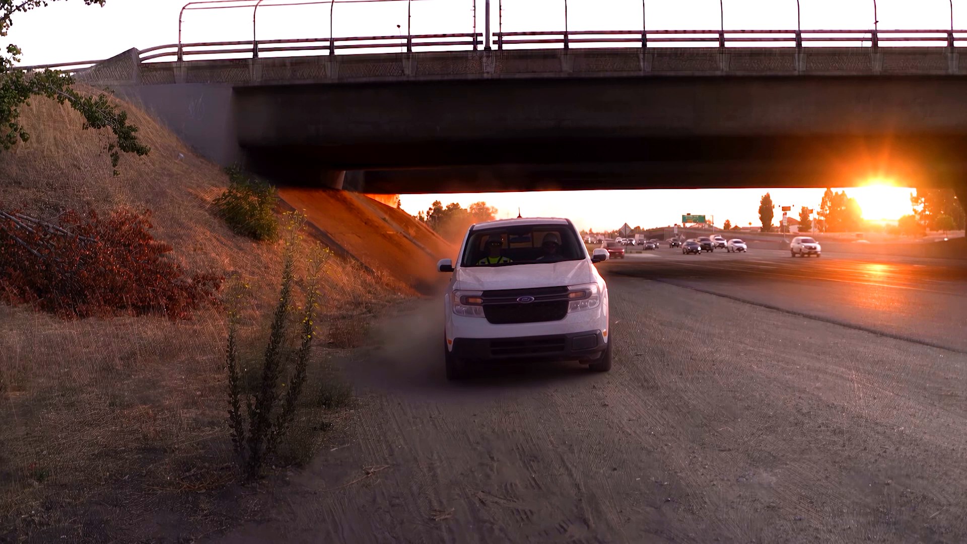 Truck under an overpass at sunset