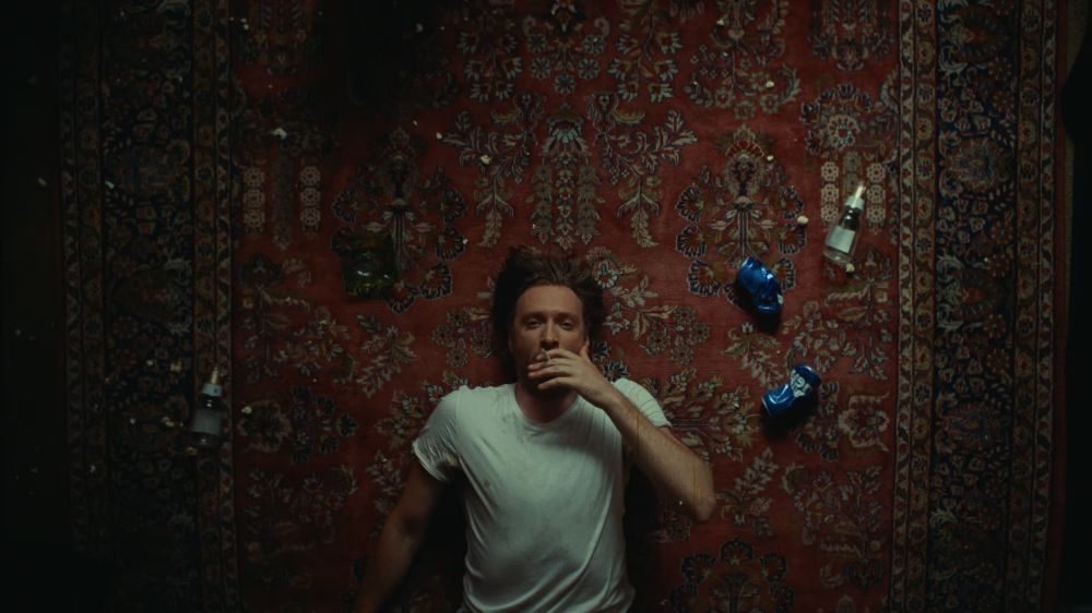Top-down of a man lying on a patterned carpet