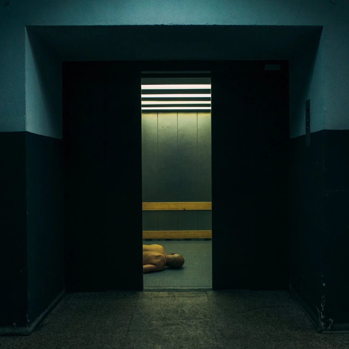 A body glimpsed through open elevator doors