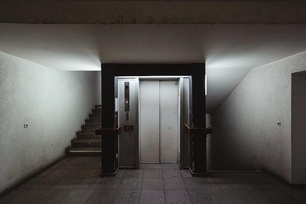 Liminal elevator lobby in flat grey light